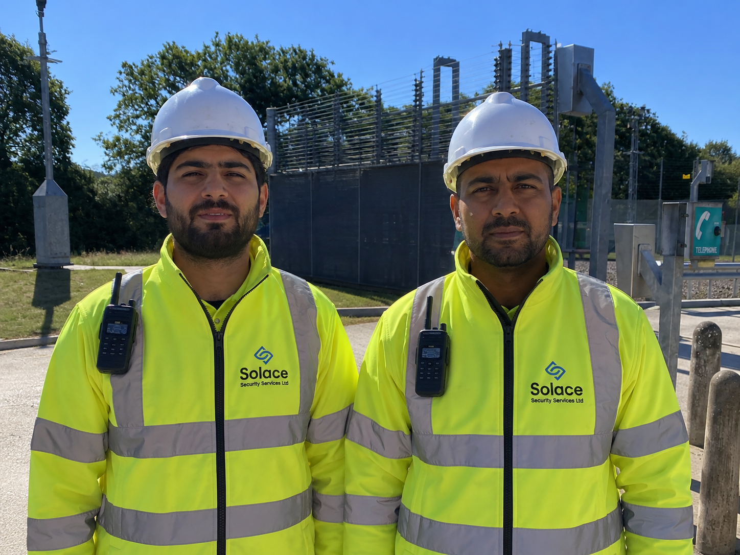 Two Solace security officers in hard hats and high visibility jackets on a construction site
